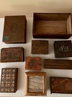 Overview of 10 assorted wooden boxes varying in size and design with carved patterns and plain finishes.