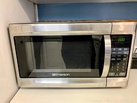 Front view of Emerson microwave oven showing stainless steel finish and door with window.