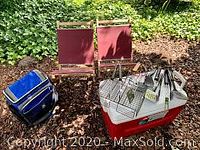 Full lot view showing large cooler, small soft cooler, two folding wooden beach chairs with maroon canvas seats, and BBQ utensils including a vegetable roasting basket.
