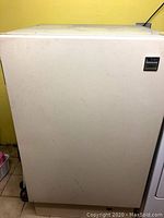 Closed view of the white Whirlpool EVO90F freezer showing textured exterior and model badge on top right corner.