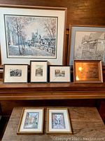 Large framed Paris watercolor and pencil drawing with six smaller framed items on a piano mantel