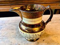Front side and overall view of the antique pitcher highlighting copper lustre and painted design