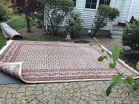 Full view of rectangular area rug laid outdoors showing overall pattern and dimensions