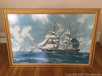 Full framed print of clipper ship on ocean under sky with gold wood frame.