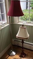 Floor and table lamps together by window showing detailed features of shades and bases