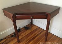 Overall view of the corner desk showing its triangular shape and wood grain finish.
