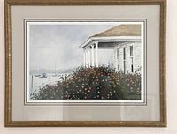 Overall view of framed watercolor print depicting a white clapboard house porch with pink flowers and sailboats in harbor