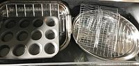 Rectangular roasting pan with 12-cup muffin tin and assorted roasting racks inside