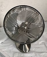 Front view of Vornado vintage metal desk fan showing silver metal grills and blades.