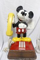 Front view of 15 inch tall Mickey Mouse phone with yellow handset and red base push-button dial