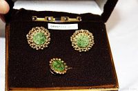 Photo showing green jade cuff links and tie tack arranged in original box labeled 'Gemstone Jade'.