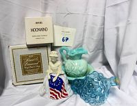 Five vintage Avon collectible items displayed on white cloth background including boxed Heart & Diamond soap dish and soap, boxed Moonwind perfumed candle, Betsy Ross figurine, blue and white swirled mini pitcher and bowl, and blue glass grapes bottle.