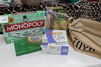 Board games Monopoly, Taboo, Calypso, Kentucky playing cards in metal case, 550 piece puzzle I Am Horse, and canvas tote bag