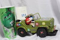 Full view of the green M&M souvenir cup alongside the army jeep candy dispenser.