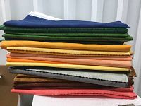 Stack of assorted lengthwise banded quilting fabric pieces in various colors, showing thickness and texture