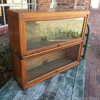 Front view of two stacked Globe-Wernicke barrister bookcases with glass doors and wood frames, showing one top cover on stack.