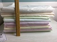 Stack of 12 cotton fabric pieces with a ruler showing approximately 12 inches for scale.