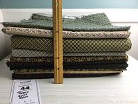 Stack of quilting fabrics shown with ruler for scale, approximately 12 inches tall.