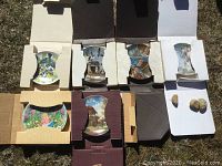 Seven collector plates arranged in cardboard holders, showing decorative designs and two small walnut shells.