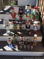 Overall group shot showing all 19 nutcrackers arranged on steps in outdoor lighting.