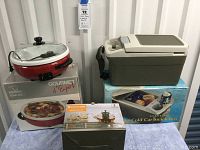Zojirushi electric skillet in red with glass lid, box visible; Sharper Image insulated snack box in beige and brown with box; Kitchen Kite teapot boxed