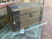 Front and side view of antique dome top trunk showing wood and metal cladding, with measurement reference.