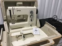 Off-white Bernina matic electronic sewing machine installed in hard plastic carrying case, lid open