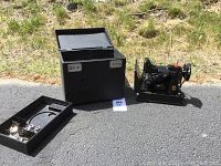 Machine, case and accessories shown together on ground
