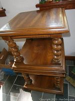 Stacked solid wood end tables showing tops, legs, and shelves.