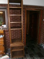 Full view of tall wooden shelf with multiple open shelves, showing wood grain and construction.
