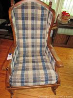 Front angled view of rocking chair showing patterned upholstery and wooden armrests.