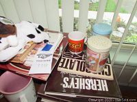 Photo showing Hershey's cookbooks, Reese's tin, perforated tins, stuffed animals, and assorted mugs and cups.