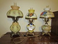 Front view of all three vintage glass ball lamps on wooden surface