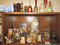Shelf with multiple porcelain and ceramic owl figurines including white Goebel owl