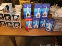 Several boxed Norman Rockwell Collector's Bells stacked together, each box featuring different artwork and text 'You are a Rockwell Collector's Bell' on them.