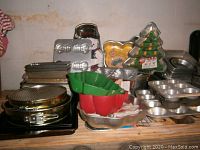 Photo showing the collection of various metal and silicone baking pans, sheets, tins, and novelty molds arranged on wooden surface.