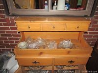 Front view of primitive wooden dry sink with three small drawers on top and two larger drawers below. Crystal items displayed on sink surface are excluded from sale.