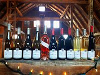 Nine bottles of Karlo Estates wine lined up on barn ledge