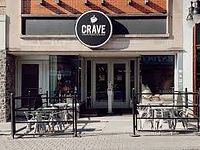 Front exterior of Crave Coffee House showing signage and entrance with outdoor seating area.