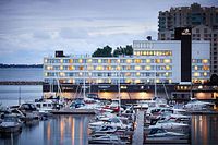Exterior view of the Delta Hotels Kingston Waterfront building with surrounding marina and Lake Ontario waterfront