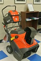 Front three-quarter view showing engine housing, controls, chute and auger