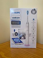 Original retail box showing toothbrush handle, charging glass and base