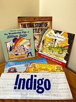 Photo showing the five children's books in the pack with visible titles and fronts on a wooden floor.