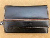 Front exterior view of black leather wallet showing tan stitching, brown piping detail, and Criale embossed logo on flap.