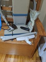 Electrolux Regency Series vacuum cleaner with all attachments and vacuum bags arranged on a wooden chair.