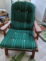 Front view of the wooden redwood recliner chair with green striped cushions featuring white buttons on seat and backrest.
