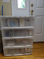 Full view of the white plastic four-drawer cabinet containing food storage containers visible through transparent drawers.