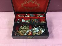 Top-down view of the jewelry box showing assorted items in compartments and bottom section