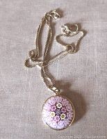 Chain and pendant displayed flat on fabric surface showing length and clasp.