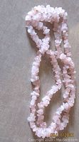 Full view of the rose quartz chip necklace showing length and bead texture